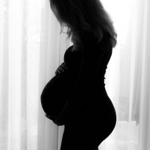 Aanstaande moeder tijdens een zwangerschapsfotoshoot op een rustige buitenlocatie, gefotografeerd in Waalwijk, Drunen, Kaatsheuvel, Tilburg of Breda.