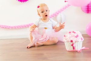 Baby genietend van een cake smash fotoshoot met kleurrijke taart, vastgelegd in Waalwijk, Drunen, Kaatsheuvel, Tilburg of Breda.